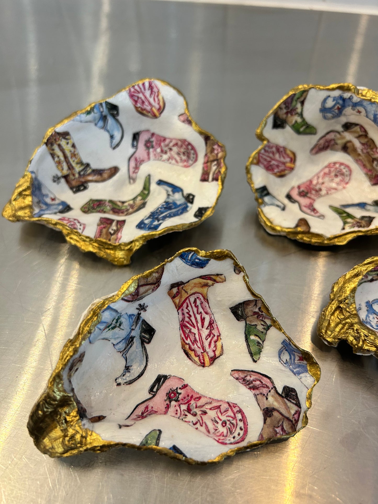 Decorative oyster shell dishes with colorful cowboy boot pattern and gold painted edges