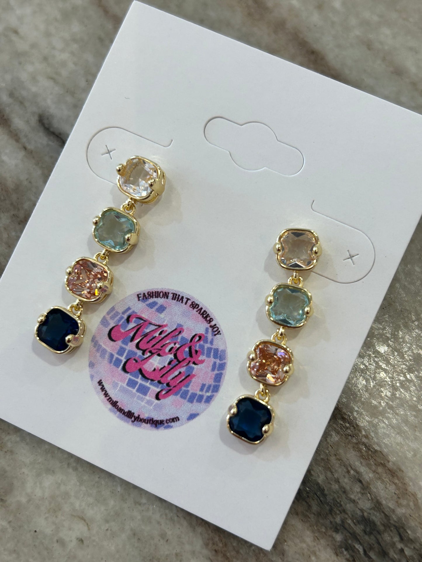 Gold drop earrings with multicolor square gemstones on jewelry card, women's fashion accessory