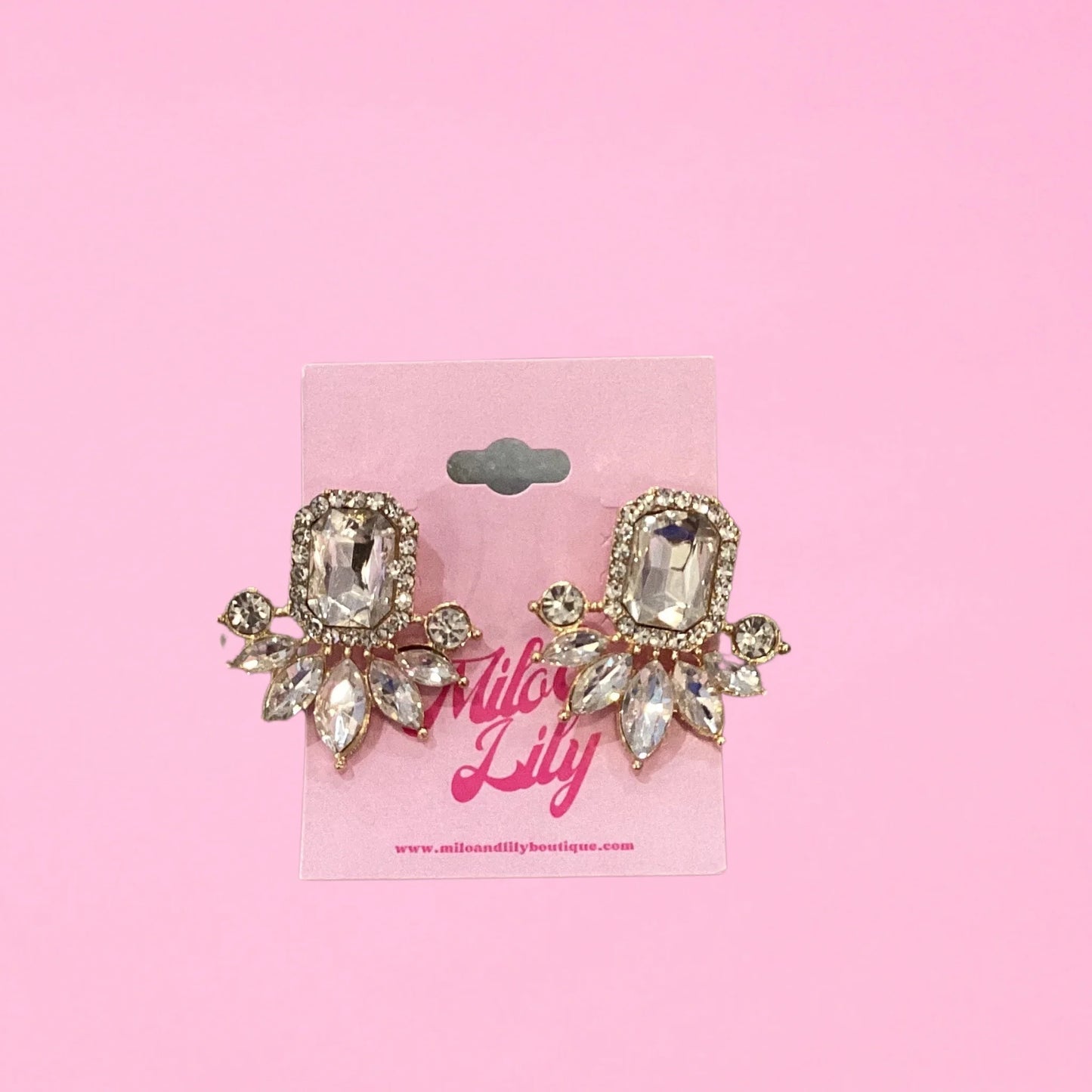 Crystal statement earrings with gold setting and diamond-shaped stones on pink background