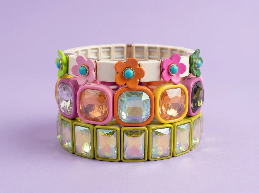 Colorful bracelet with floral and gemstone designs on a light purple background