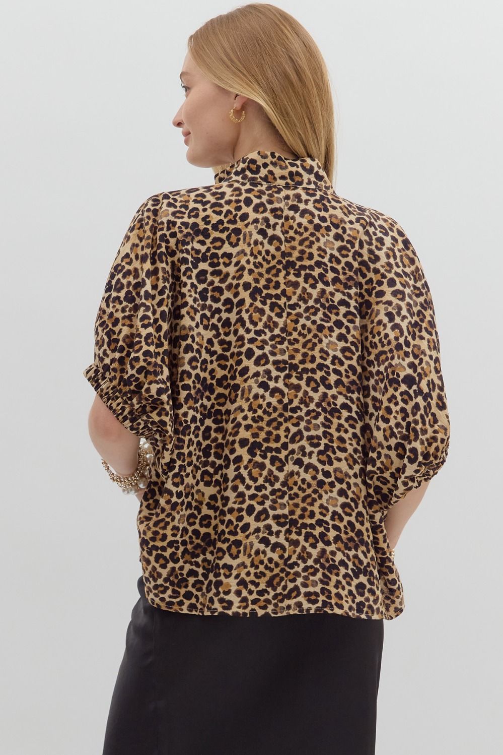 Back view of the animal print blouse featuring gathered sleeves and a seamless drape, showing full coverage and flowy silhouette.