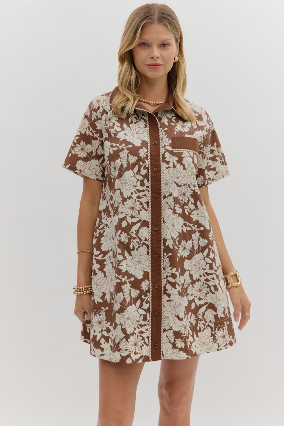 Woman wearing the Espresso Flora Dress, a short sleeve espresso brown shirt dress with ivory floral print, collared neckline, front pocket, and full button front – Milo & Lily Boutique.