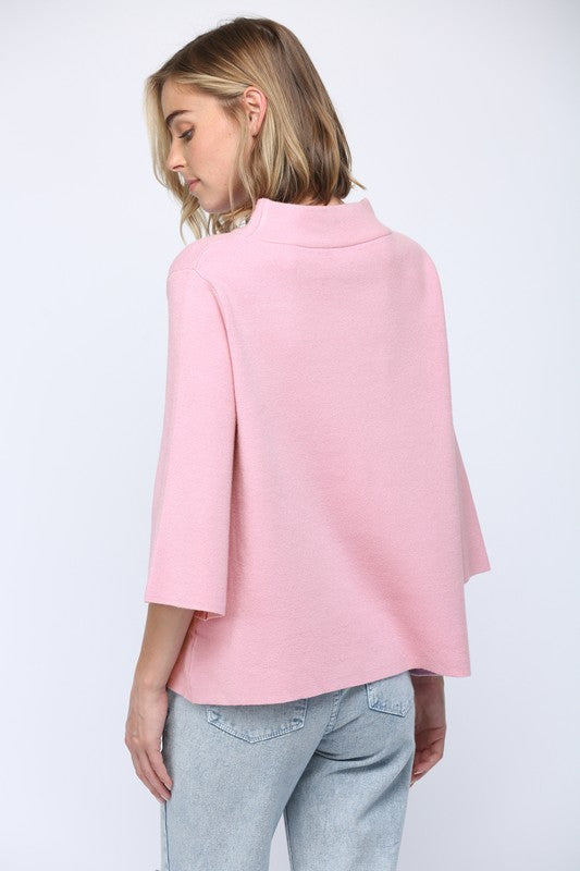 Woman wearing a pink cape over a white background