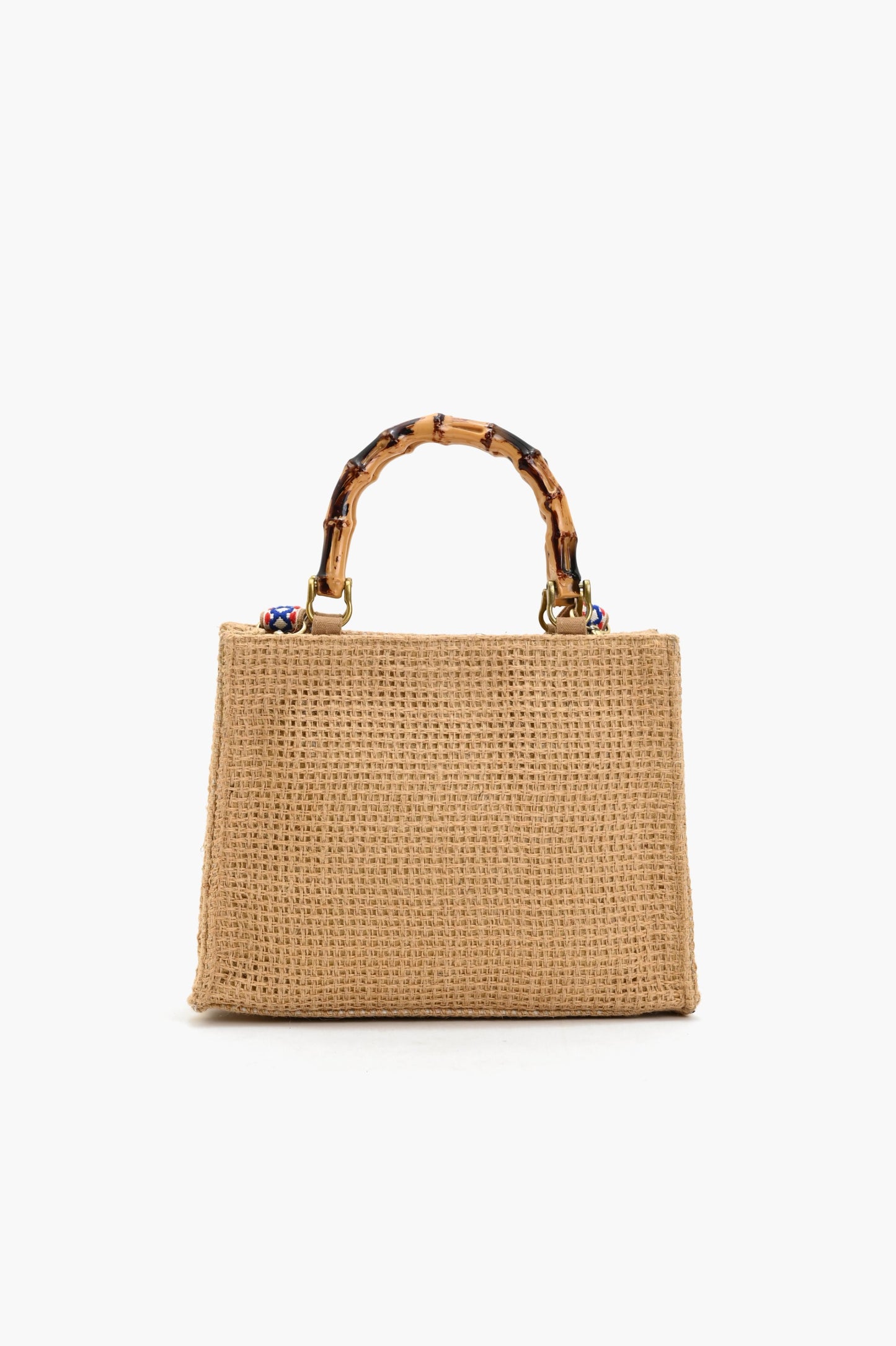 Natural woven tote bag with bamboo-style handles and colorful embroidered designs including a rainbow, heart, clover, eyes, and the phrase “good things are coming.”