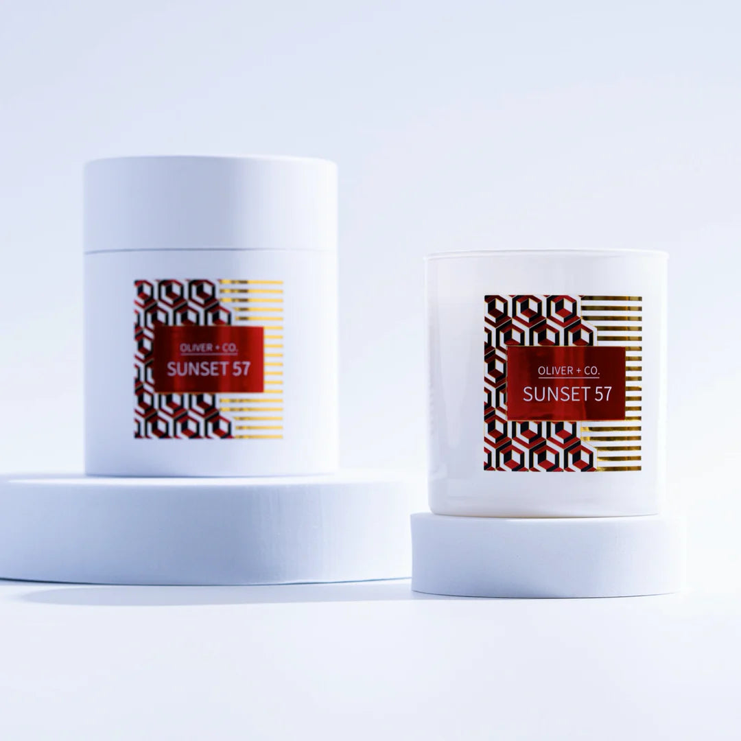 Two candles labeled 'Oliver & Co Sunset 57' on a white background