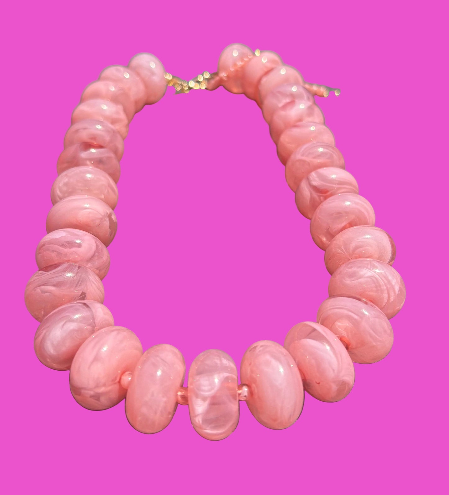 Pink beaded necklace on a pink background