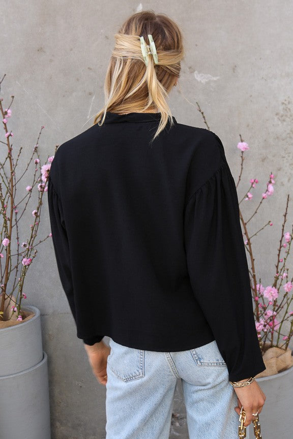 Back view of The City Muse Tie Blouse showing soft drape and gathered shoulder detail.
