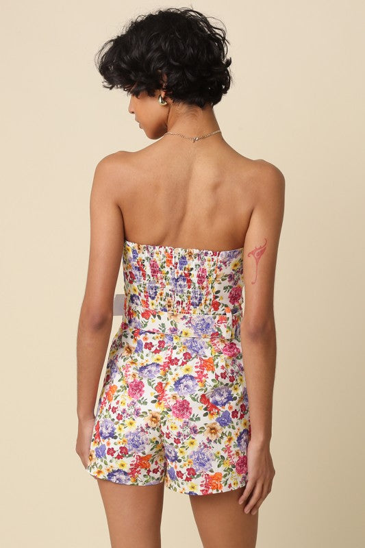 Woman wearing a strapless floral dress on a beige background