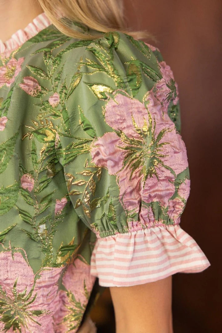 Close-up of green floral embroidered top showing pink and gold textured floral design and striped ruffle sleeve trim — boutique embroidered blouse from Milo & Lily Boutique.