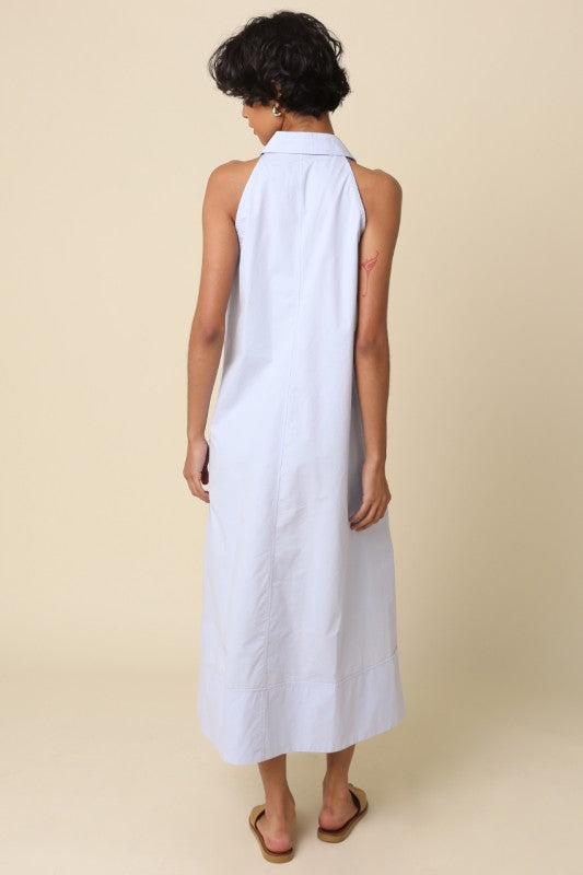 Woman wearing a white sleeveless dress against a beige background