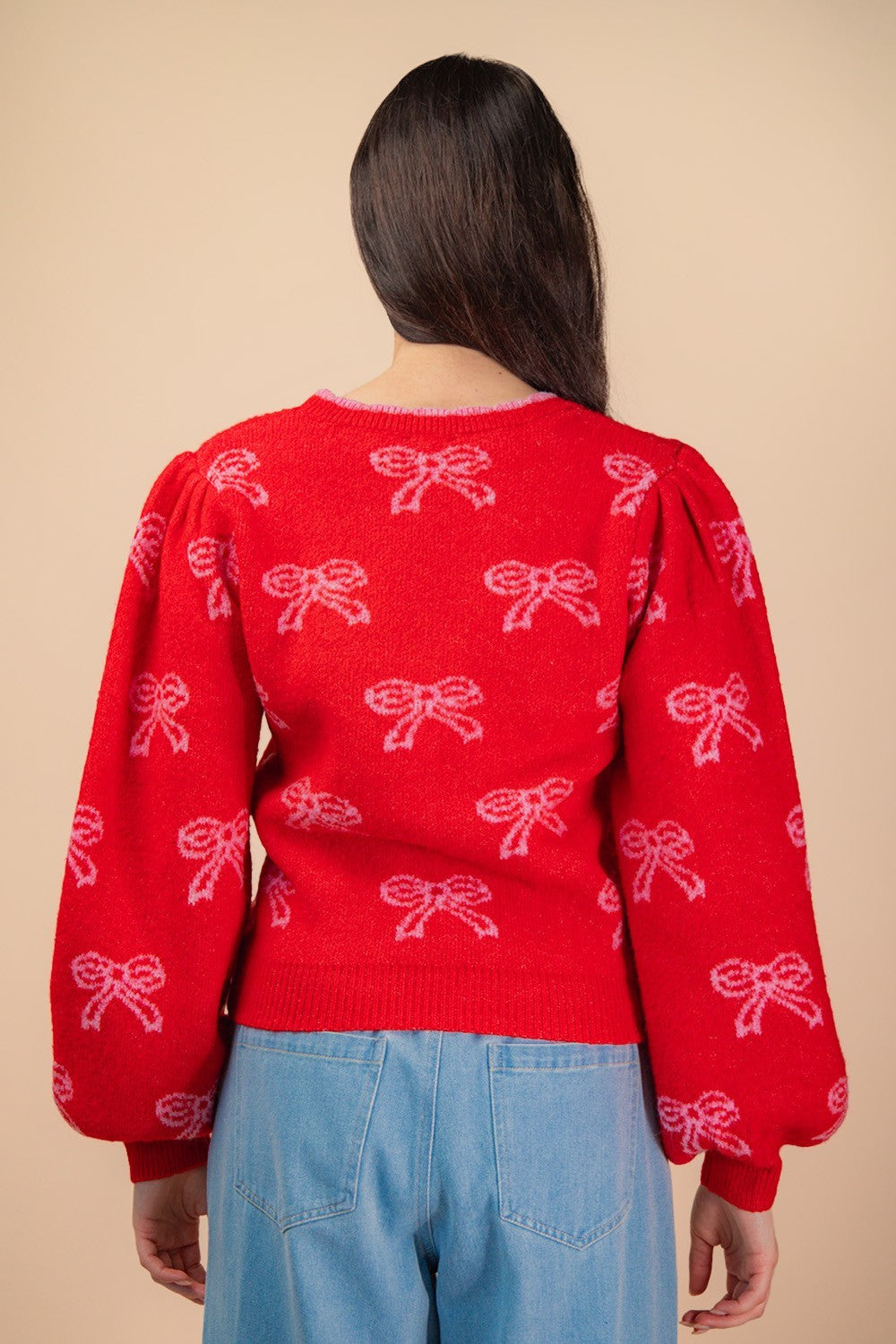 Back view of red holiday bow sweater with puff sleeves and pink bow pattern — cozy festive knit from Milo & Lily Boutique.
