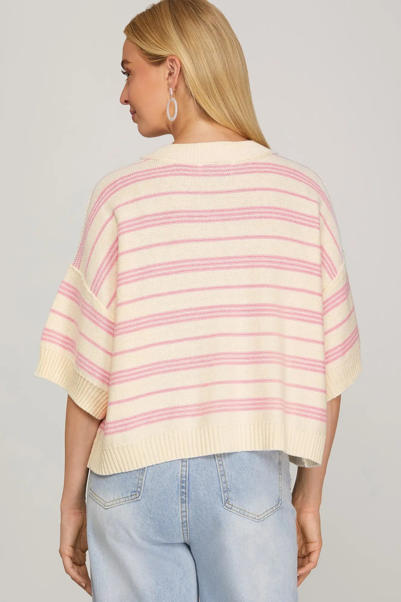 Back view of cream and pink striped drop-shoulder sweater