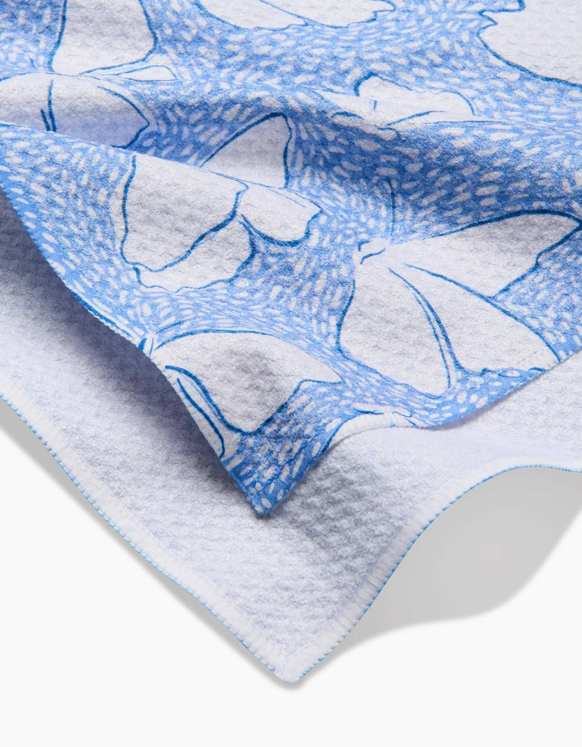 White textured towel with blue butterfly print and decorative stitched edge