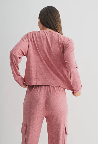 Woman wearing pink long sleeve lounge set with cargo pants, shown from the back