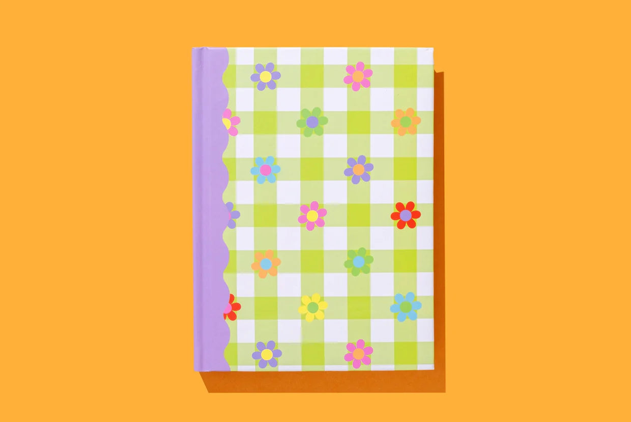Colorful floral notebook with green gingham cover and purple spine on orange background