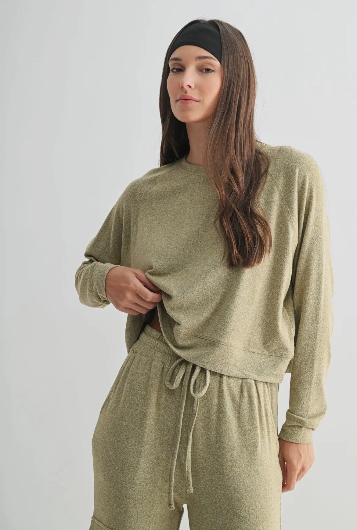 Woman wearing an olive green loungewear set with long sleeves and drawstring pants