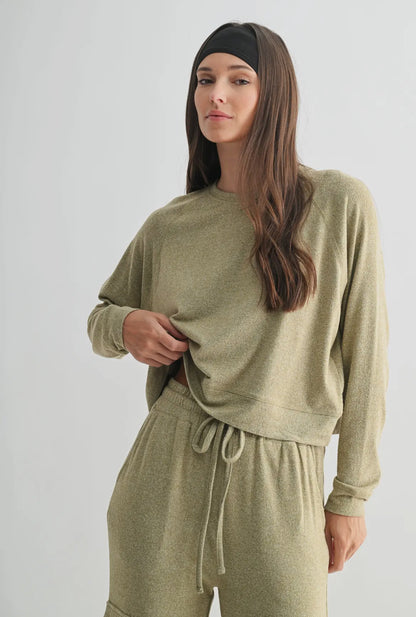 Woman wearing an olive green loungewear set with long sleeves and drawstring pants