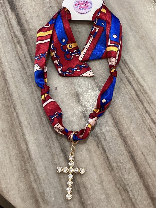 Colorful chain print fabric necklace with rhinestone cross pendant on marble surface