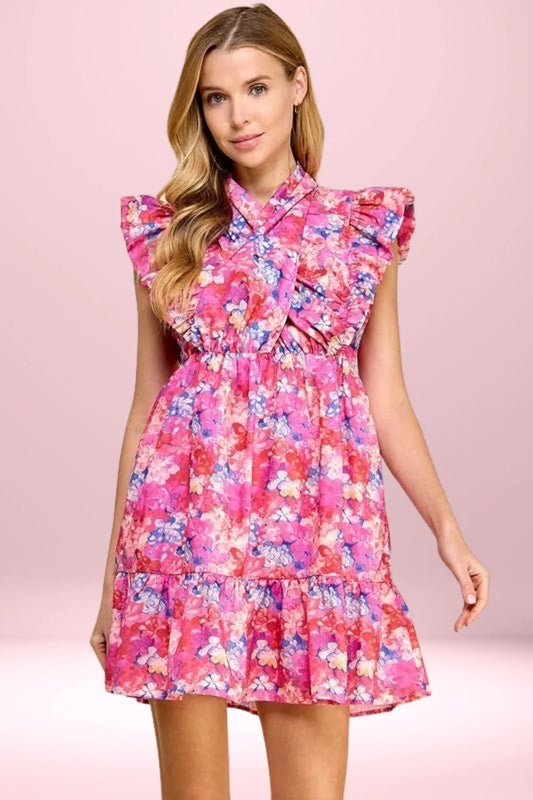 Woman wearing a pink floral ruffle mini dress with cap sleeves and a tiered skirt