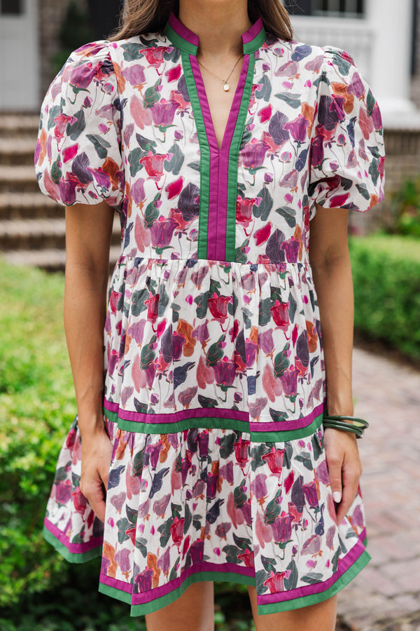 Woman wearing a puff sleeve floral print mini dress with green trim outdoors