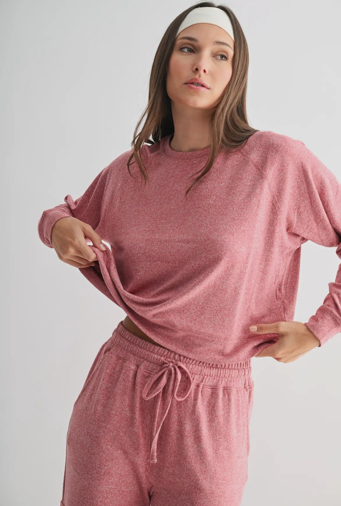 Woman wearing a pink loungewear set with long sleeves and drawstring pants