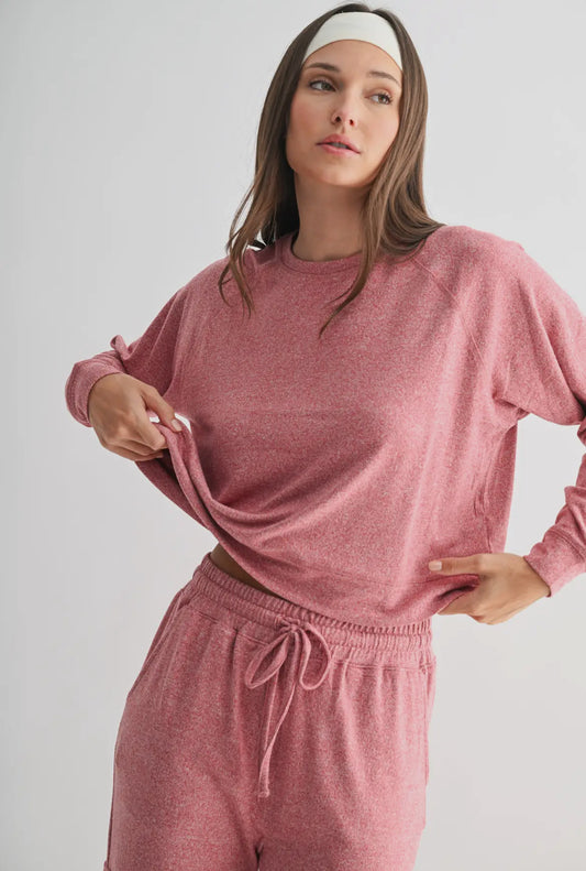 Woman wearing a pink loungewear set with long sleeves and drawstring pants
