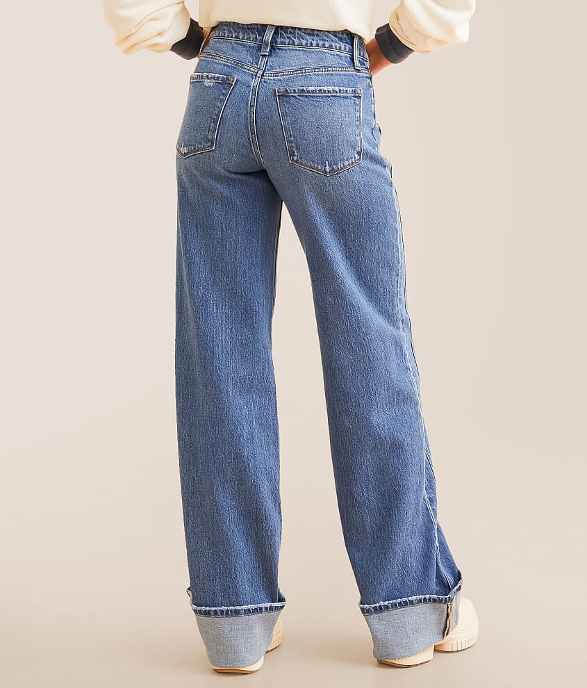 Back view of a woman wearing high-waisted wide leg blue jeans with cuffed hems