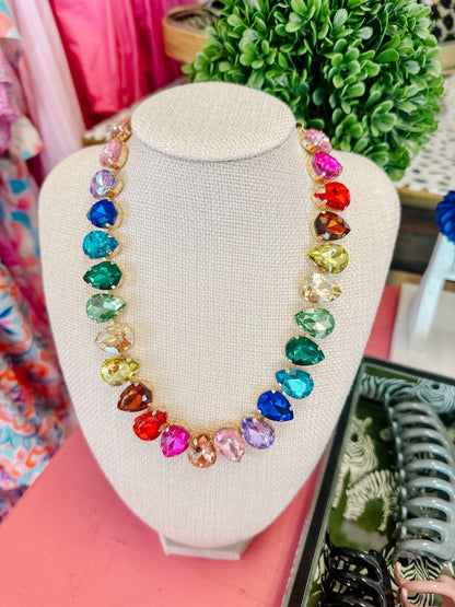 Colorful gemstone statement necklace with teardrop crystals on display bust