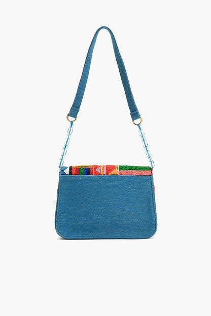"Back view of a teal blue shoulder bag with a plain fabric panel and beaded strap detailing, showcasing the colorful geometric beading peeking over the top."