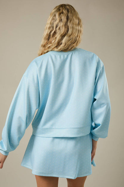 Person wearing a light blue outfit against a beige background