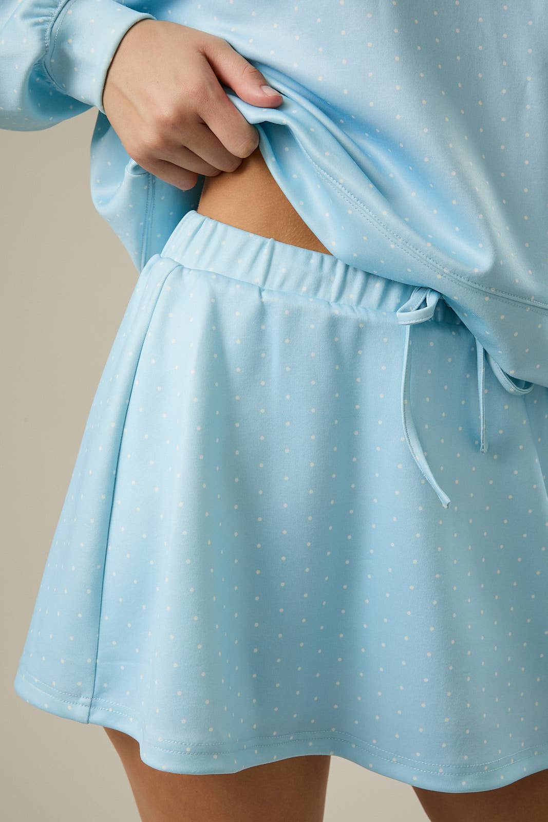 Light blue polka dot skirt worn with a matching top on a neutral background