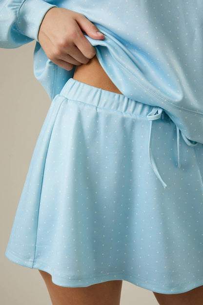 Light blue polka dot skirt worn with a matching top on a neutral background