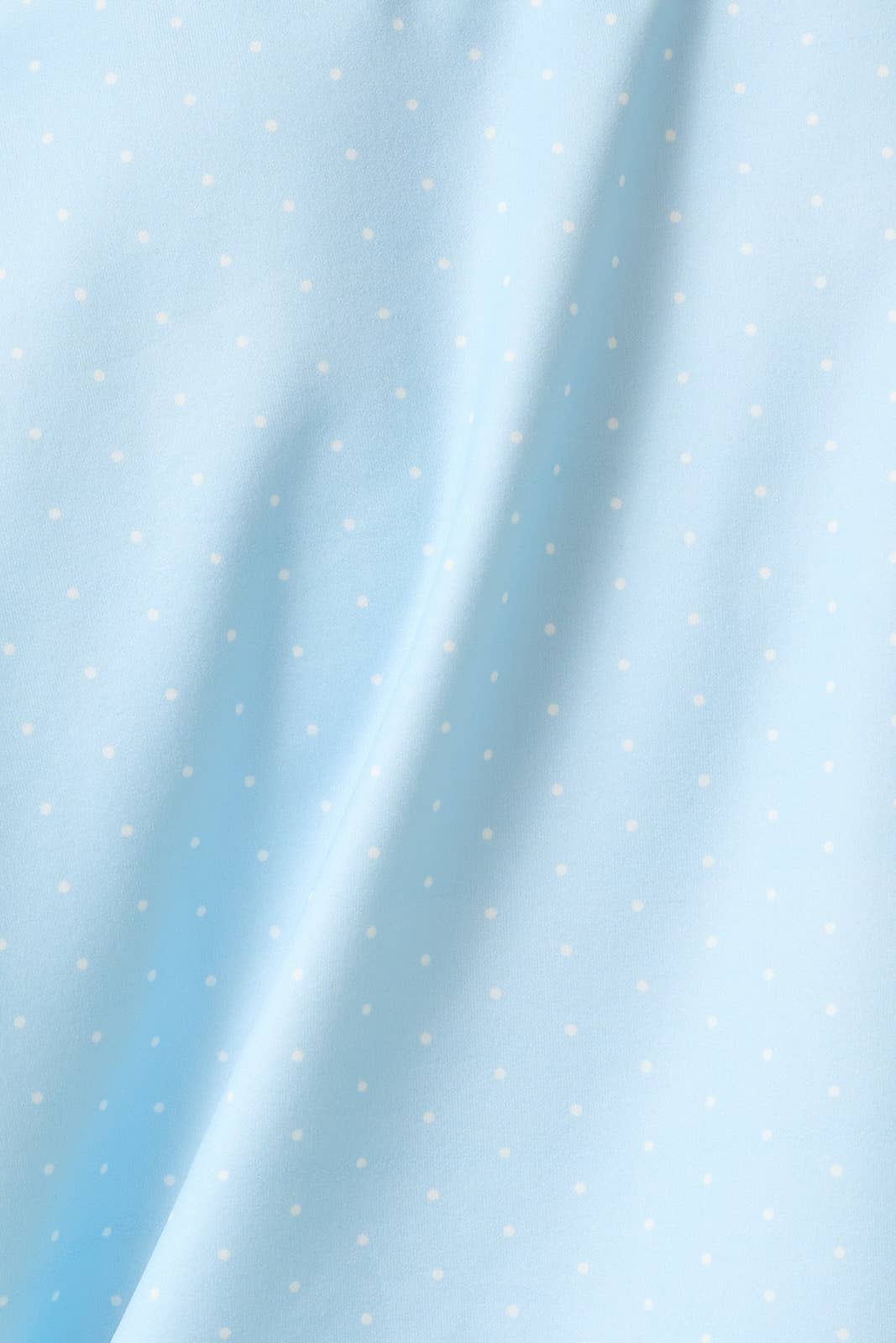 Light blue fabric with a small white polka dot pattern, shown with soft folds and a smooth texture.