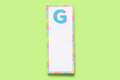 Colorful notepad with letter G on top, pastel border, and lined paper on green background