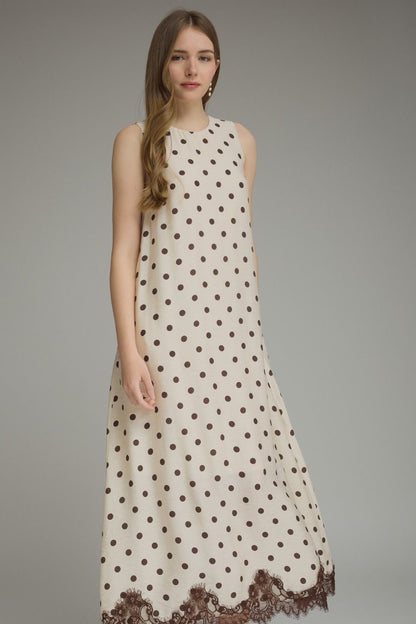 Woman wearing a polka dot dress with lace trim on a gray background