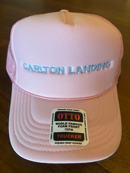 Pink cap with 'Carlton Landing' branding and Otto label on a wooden surface