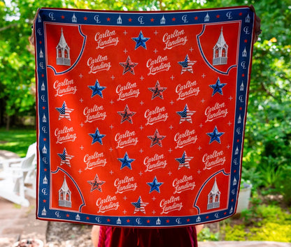 Red Scarf with 'Carlton Landing' pattern held by a person outdoors