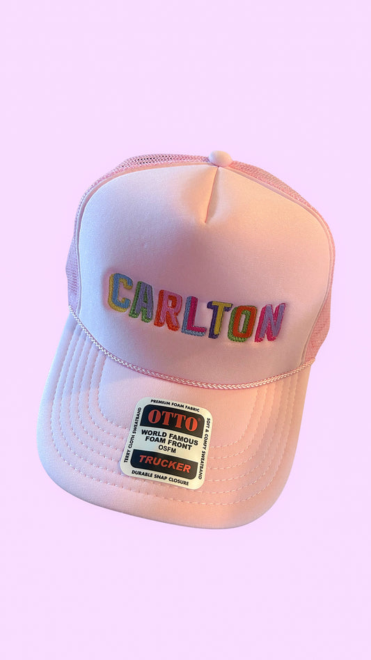 Pink cap with 'Carlton' text on a pink background