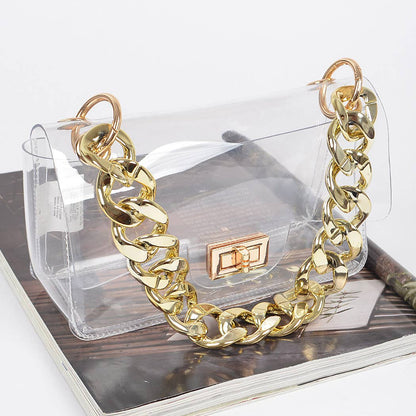 Gold chain necklace on a transparent handbag with a wooden surface underneath