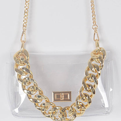 Gold chain necklace on a clear handbag with a white background