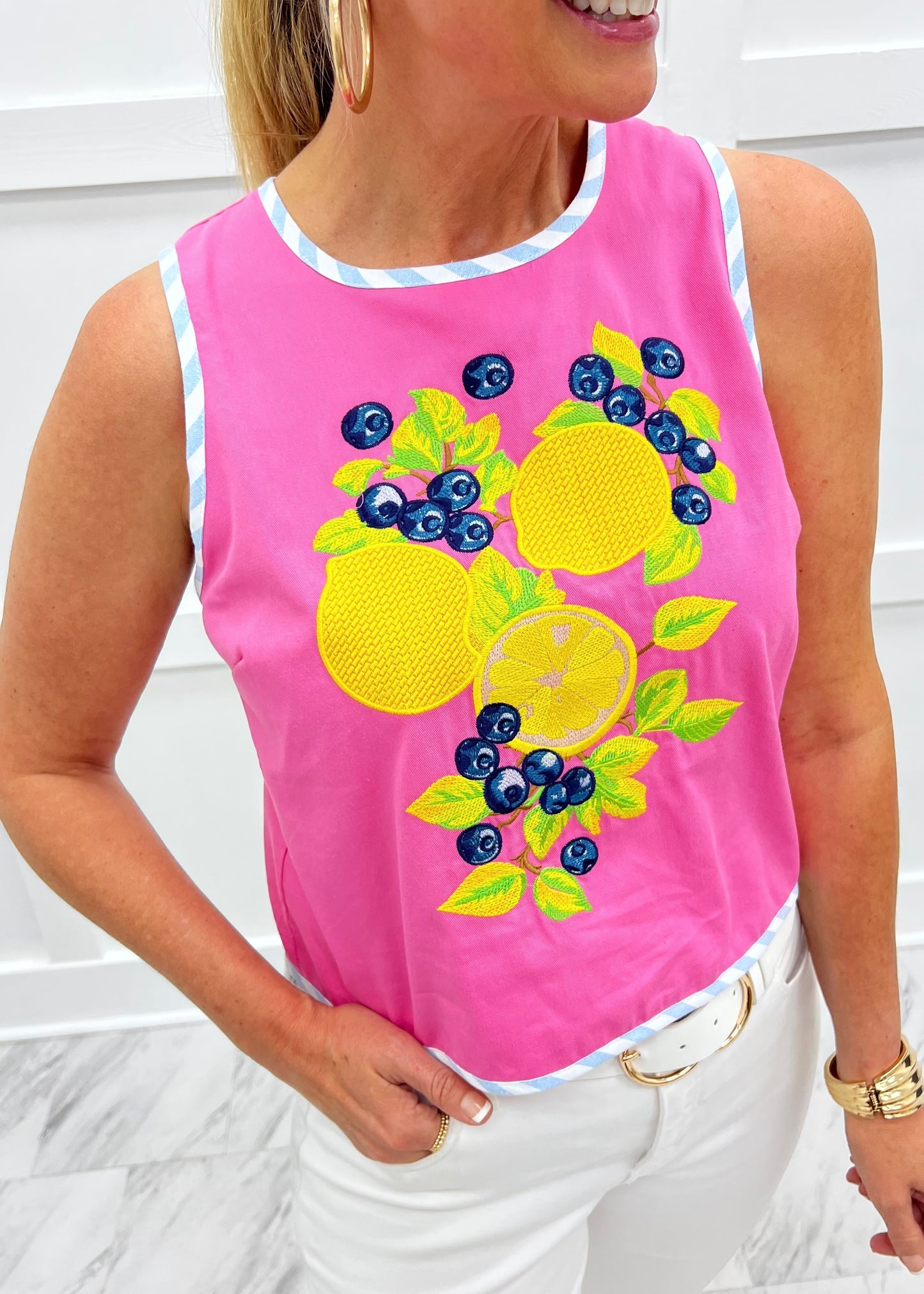 Person wearing a pink sleeveless top with lemon and blueberry design.