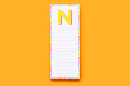Colorful letter N notepad with checklist lines on orange background, stationery accessory