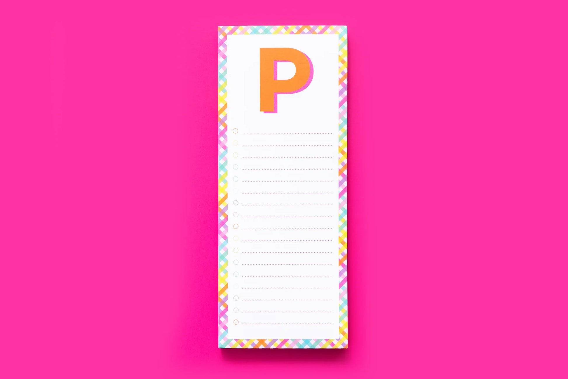 Colorful notepad with letter P, checkboxes, and plaid border on pink background