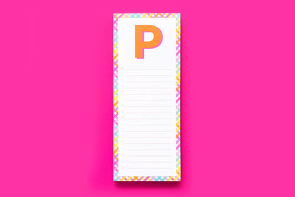 Colorful notepad with letter P, checkboxes, and plaid border on pink background