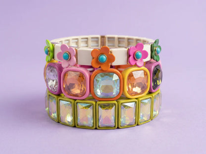 Colorful bracelet with floral and gemstone designs on a light purple background