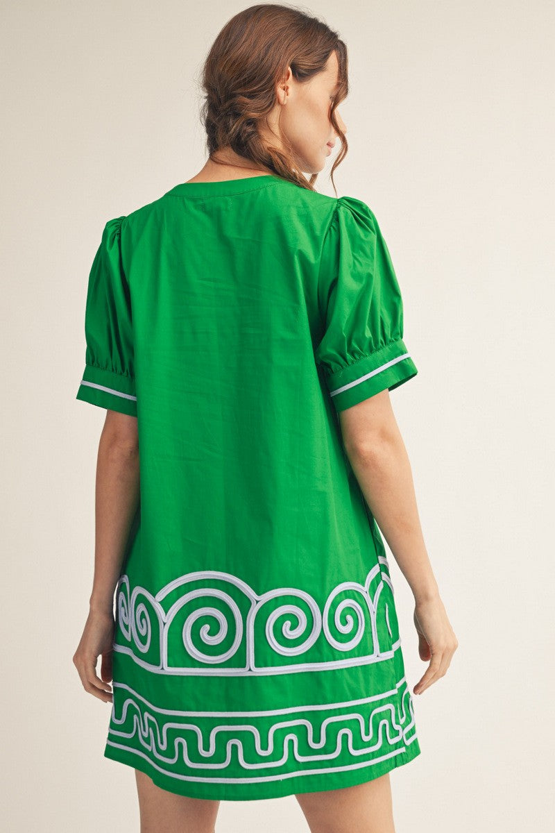 Woman wearing a green dress with white patterns on a beige background