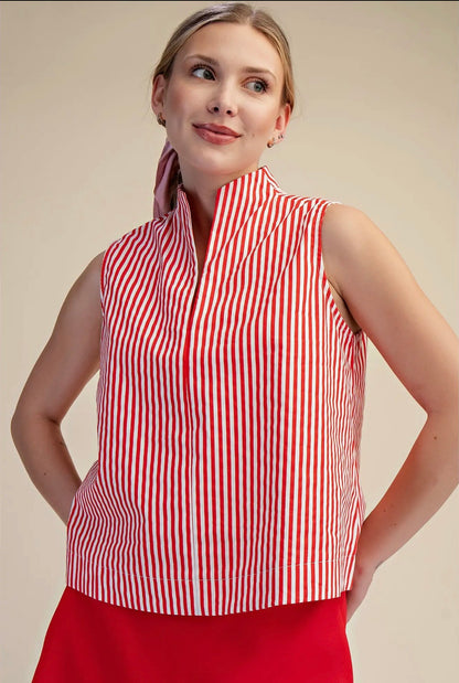 Woman wearing a red and white striped sleeveless top against a beige background