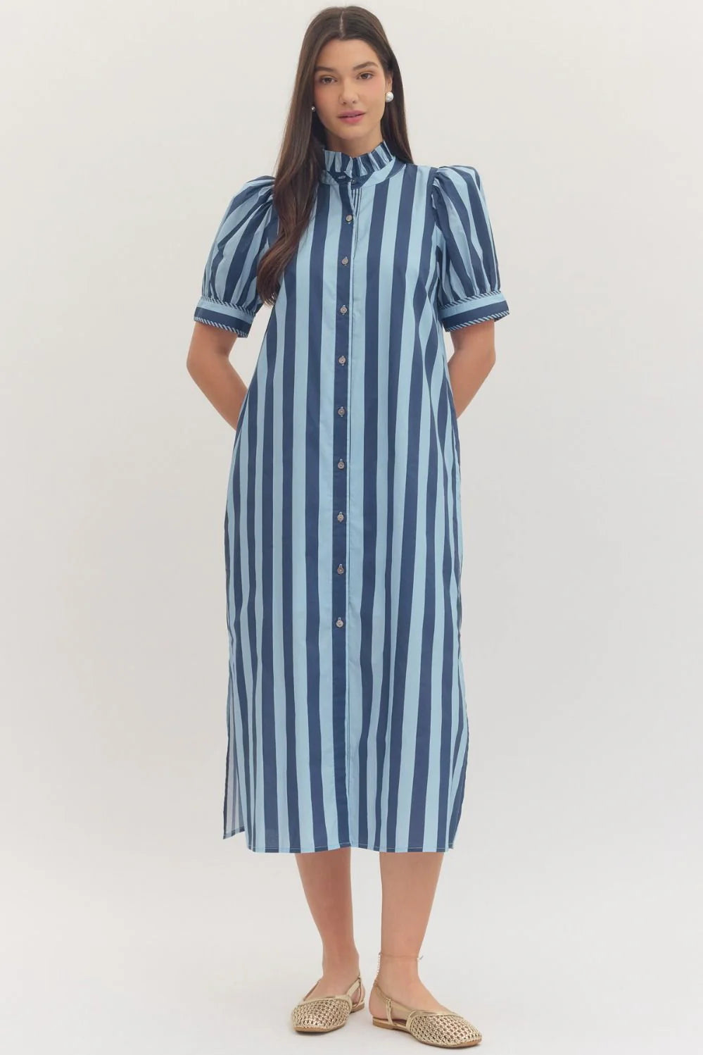 Woman wearing a navy blue and light blue striped dress on a white background