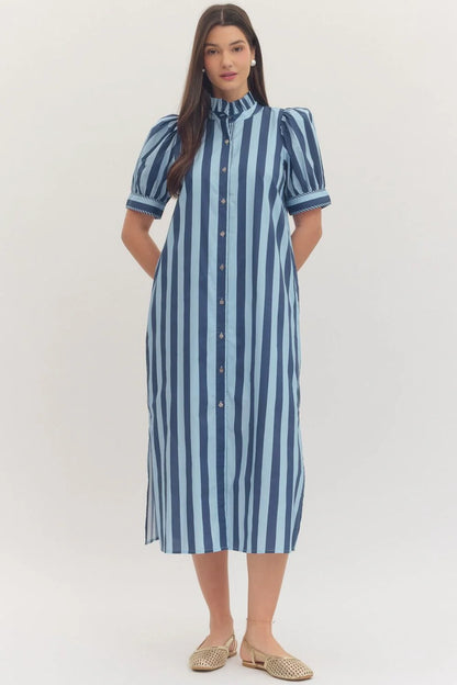 Woman wearing a navy blue and light blue striped dress on a white background