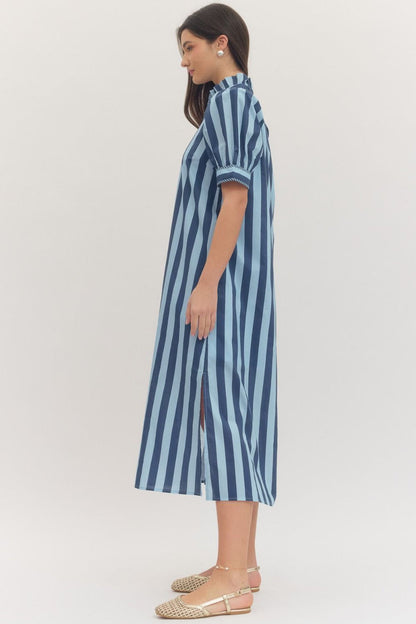 Woman wearing a navy blue and light blue striped dress on a white background